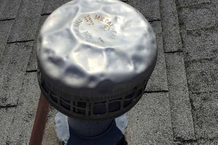 Hail damage to a metal roof exhaust vent. 